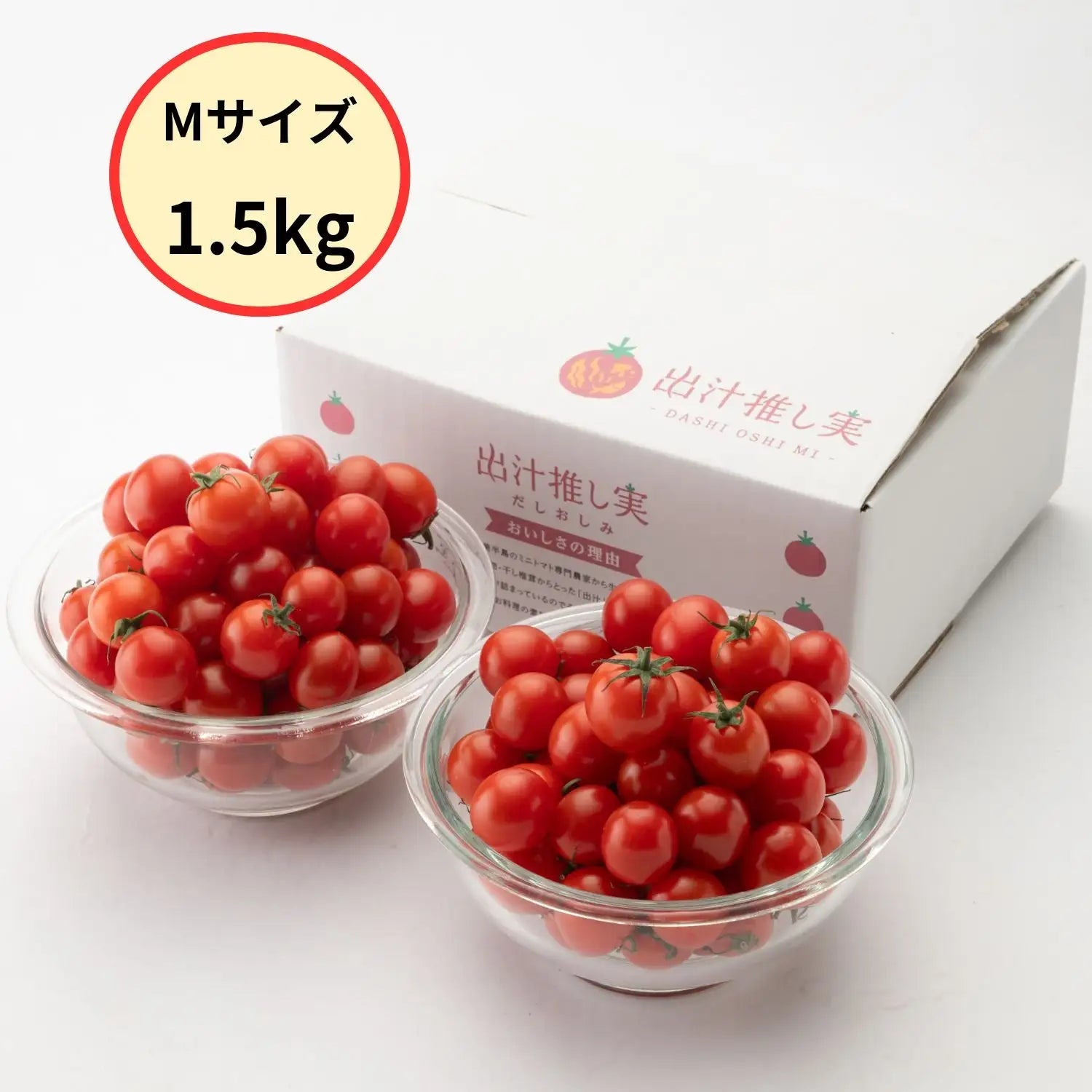 「Mサイズ1.5kg」のバッジ付きで、2つのガラスボウルに山盛りのミニトマトと「出汁推し実」の箱を並べた写真