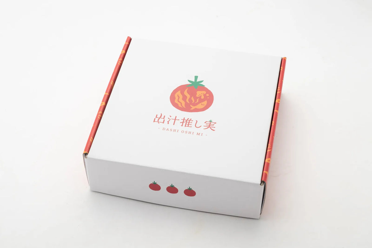 白背景に「出汁推し実」のロゴが入った白い化粧箱（外箱）を正面から撮影した商品パッケージ写真